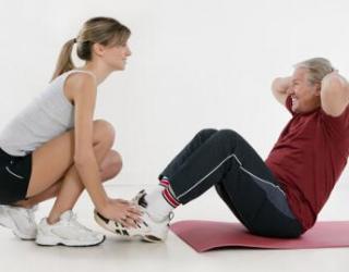 Starker Rücken Mann macht Sit ups mit Trainerin